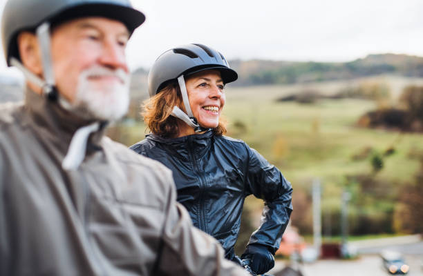 istock Active senior couple with electrobikes standing outdoors on a road in nature. 1125012932