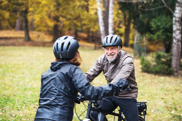 istock Active senior couple with electrobikes standing outdoors on a road in nature. 1125012945