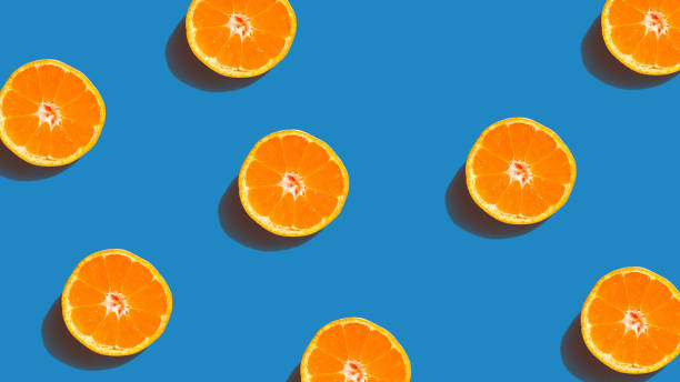 istock Colorful fruit pattern of fresh orange slices on blue background. From top view 1125015454