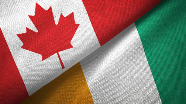 istock Cote d'Ivoire Ivory coast and Canada two flags together textile cloth, fabric texture 1125020359