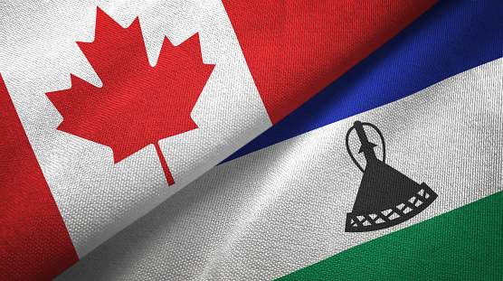 Lesotho and Canada flags together textile cloth, fabric texture