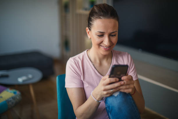 istock Woman sitting at home and using smart phone 1125025774