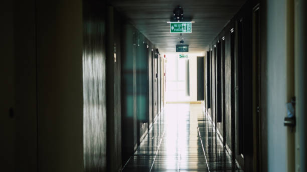 istock Walkway to the fire escape door, Fire exit sign over corridor walkway in apartment building, Exit signs for emergency along the way in an office 1125026067