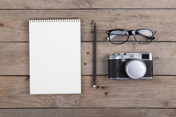 istock Notepad, glasses and camera on the wooden desk 1125027746