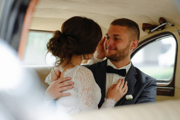 istock Beautiful happy young bride and groom looking from retro auto 1125030389