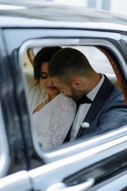 istock Beautiful happy young bride and groom looking from retro auto 1125030454