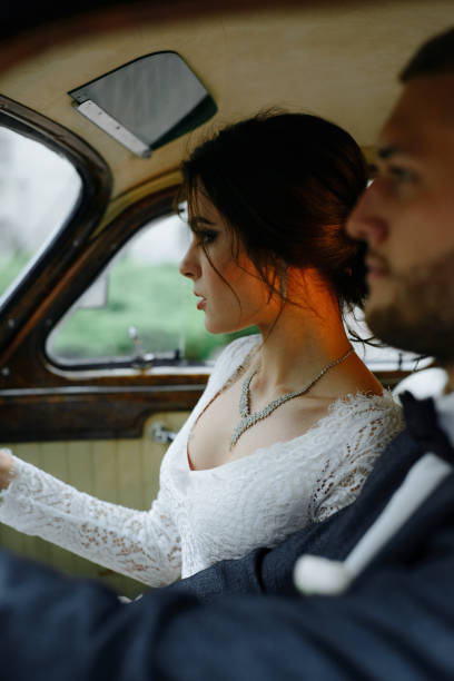 istock Beautiful happy young bride and groom looking from retro auto 1125030650