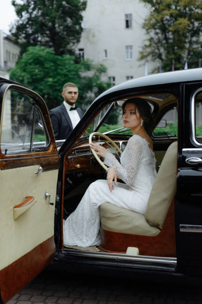istock Beautiful happy young bride and groom looking from retro auto 1125030701