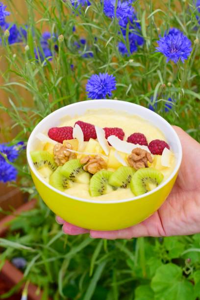 Mango banana pineapple smoothie bowl topped with raspberry, kiwi, walnut and coconut chips Mango banana pineapple smoothie bowl topped with raspberry, kiwi, walnut and coconut chips baobab flower stock pictures, royalty-free photos & images