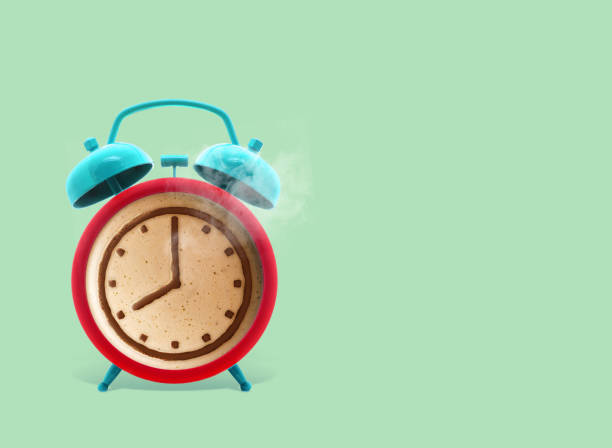 istock Twin bell alarm clock with coffee mug on green background, Coffee clock, creative idea. minimal concept, coffee cup time clock concept design 1125032061