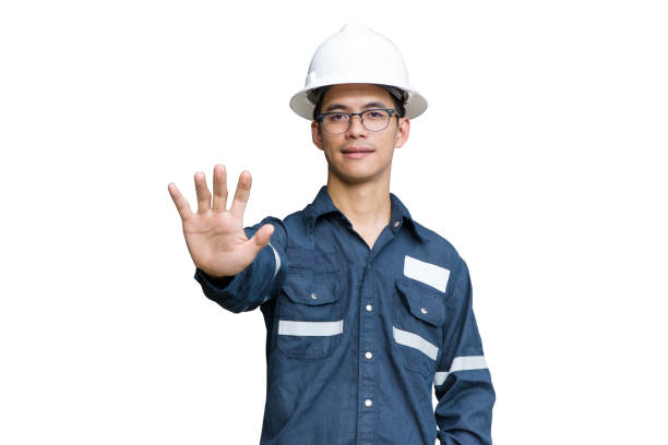 istock Engineer or Technician in white helmet, glasses and blue working shirt suit while push hand to stop working, isolated on white, for safety first concept with clipping path. 1125033125