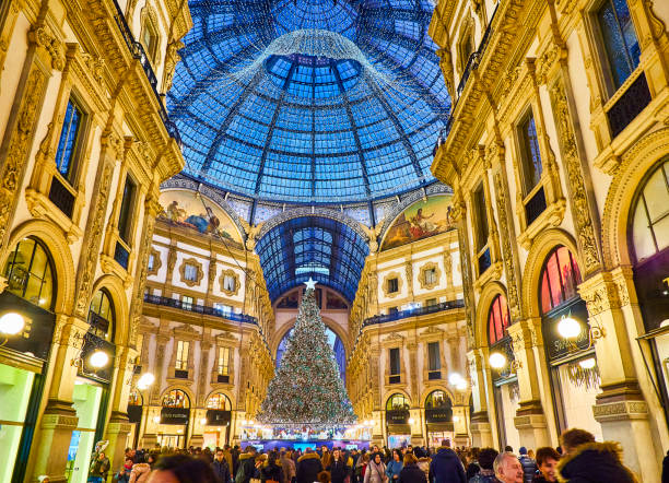 The Galleria Vittorio Emanuele II illuminated by christmas lights and a shinny christmas tree. Milan, Lombardy, Italy. Milan, Italy - December 29, 2018. People walking on The Galleria Vittorio Emanuele II illuminated by christmas lights and a shinny christmas tree. Milan, Lombardy, Italy. galleria vittorio emanuele ii stock pictures, royalty-free photos & images