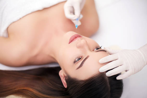 istock Attractive woman at plastic surgery with syringe in her face 1125048659