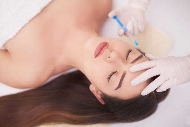 istock Attractive woman at plastic surgery with syringe in her face 1125048676
