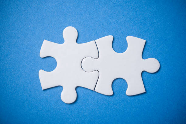 istock Two connected jigsaw puzzle pieces on blue  background. The concept of finding the right solutions in teamwork. 1125059850