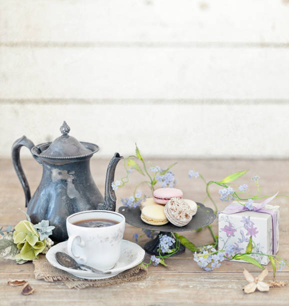 istock Vintage Easter Brunch with Tea and Macaroons on an Old Rustic White Wood Background 1125065553