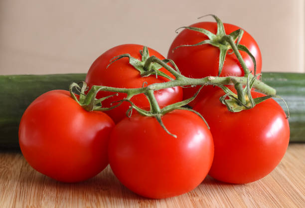 istock delicious red tomatoes and a cucumber, arranged on a bamboo plate. 1125066694