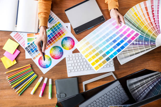 istock Image of female creative graphic designer working on color selection and drawing on graphics tablet at workplace with work tools and accessories, top view workspace 1125070285