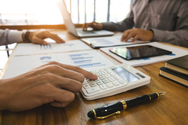 istock Business man analysis data document with accountant calculating about fee tax at a office 1125071129