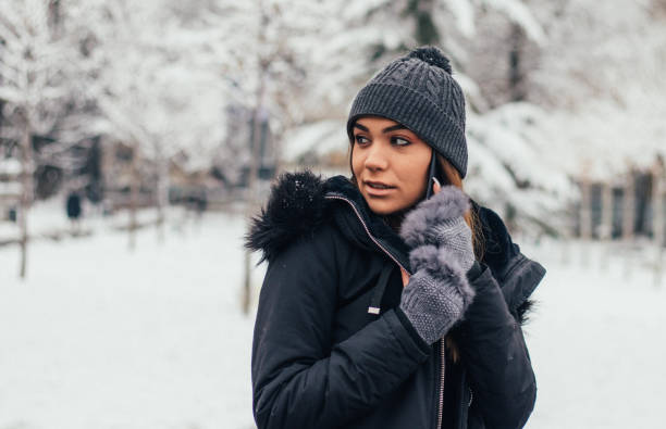 istock Pretty girl using smart phone in snow 1125074417