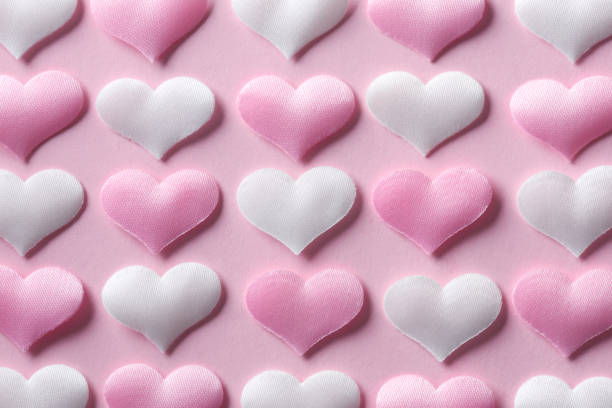 istock Pink and white textile hearts on pink background 1125075905