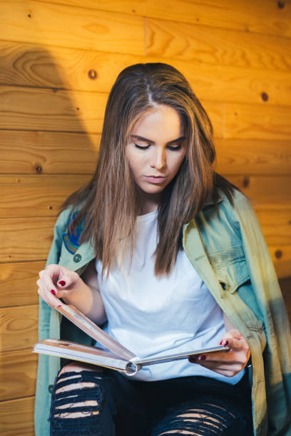 istock Young woman sitting in cafe and looking in menu for order. 1125075977