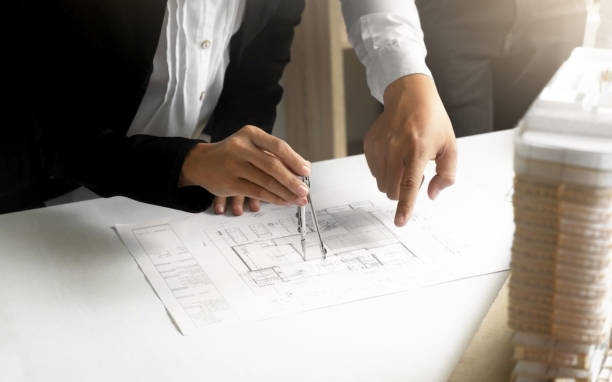 istock Hands of Engineers working on blueprint at a workplace, Construction and building concept 1125076055