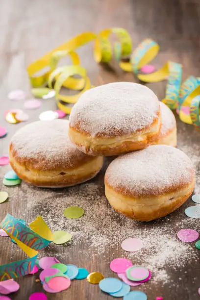 Krapfen, Berliner or  donuts with streamers and confetti. Colorful carnival or birthday image