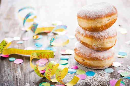 Krapfen, Berliner or  donuts with streamers and confetti. Colorful carnival or birthday image