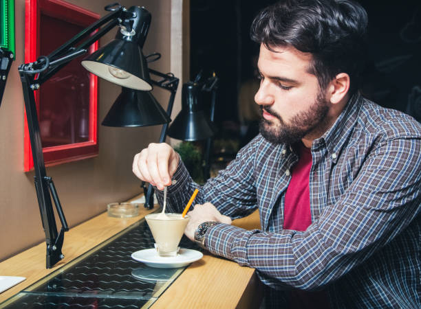 Young man relaxing with favorite coffee in cafe.