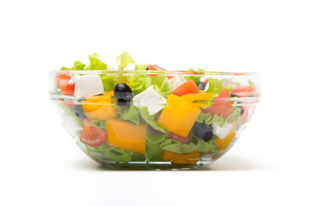 istock Greek salad in a glass bowl Isolated on white background 1125077883