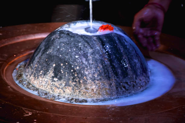 black stone shiva lingam in a temple getting worship by pouring milk - shivalinga imagens e fotografias de stock