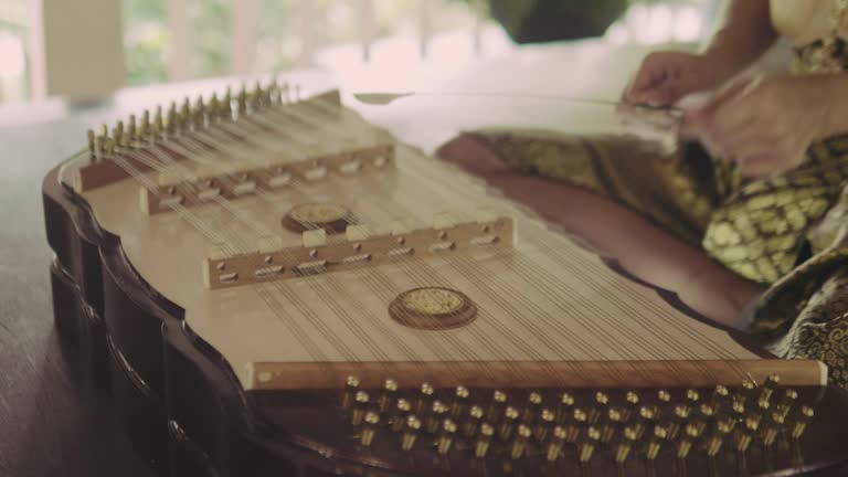 Thai woman playing Thai wooden dulcimer musical instrument