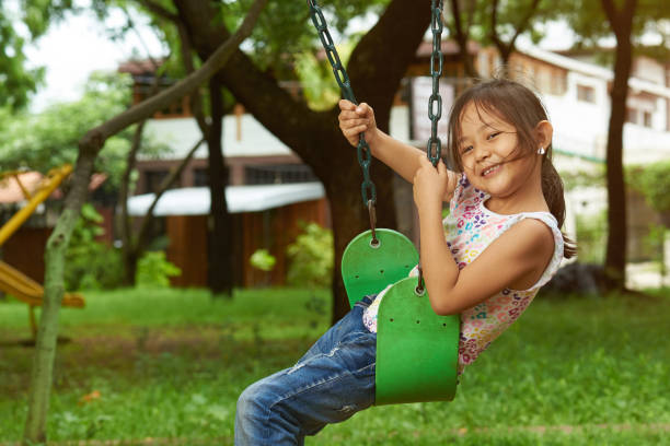 istock Asian girl on a swing at a park 1125084835