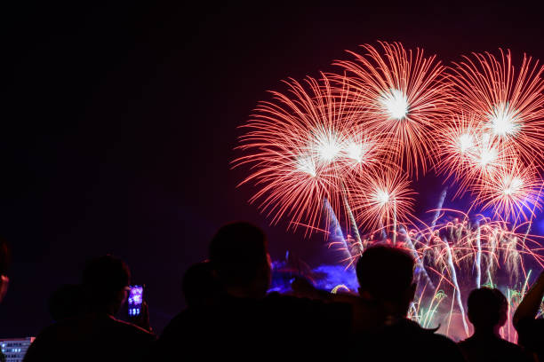 istock Crowd watching fireworks and celebrating city founded. Beautiful colorful fireworks display in the urban for celebration on dark night background. 1125087268