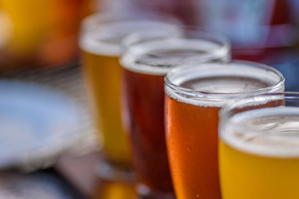 Beer flight at outdoor beer garden in summertime Beer flight macro at microbrewery in summer sunlight microbrewery photos stock pictures, royalty-free photos & images