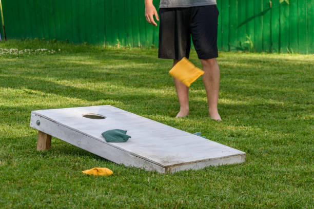 gars jouer cornhole dans l’arrière-cour - cornhole leisure games outdoors color image photos et images de collection