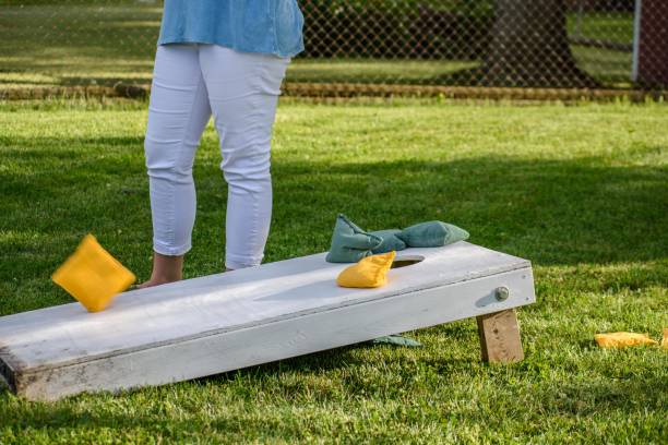 femme jouant cornhole lors d’une fête familiale en été - cornhole leisure games outdoors color image photos et images de collection