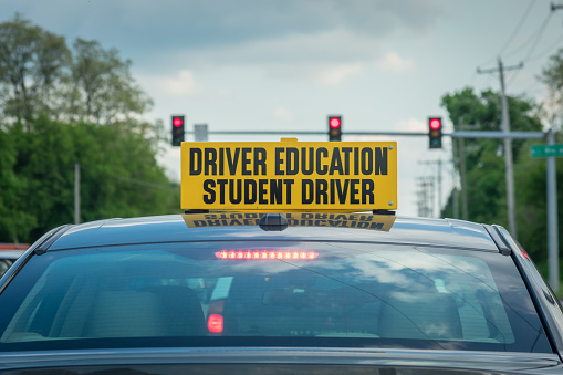 Drivers ed sign on car roof at stoplight in daylight