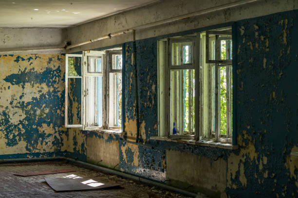 istock Old abandoned house with windows. Colorful cement stone wall. Cracked wall with old layers of paint in abandoned house 1125088953