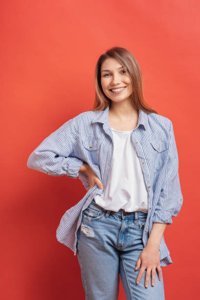 istock Pretty female model posing with a smiling face expression on red background 1125090753