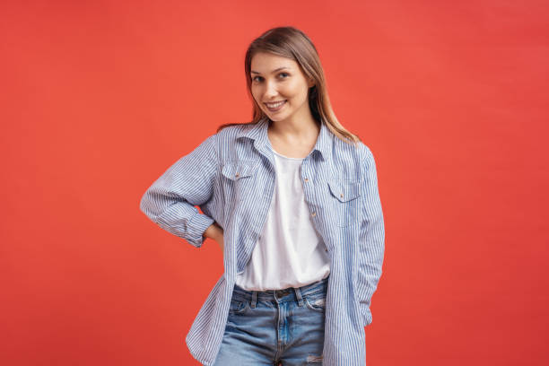 istock Pretty female model posing with a smiling face expression on red background 1125090812