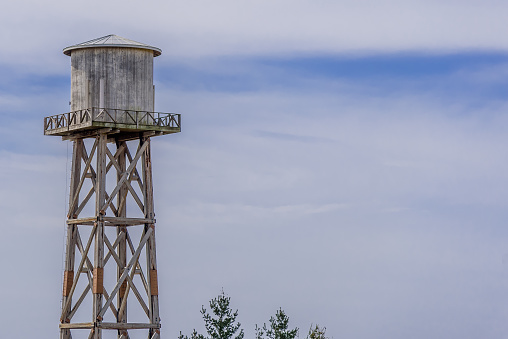 Vintage water tower standing in blue sky with copy space