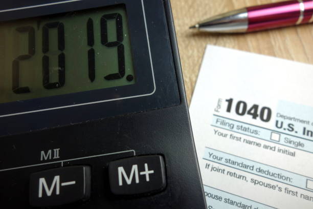 istock Number 2019 on calculator with 1040 form and pen 1125097380