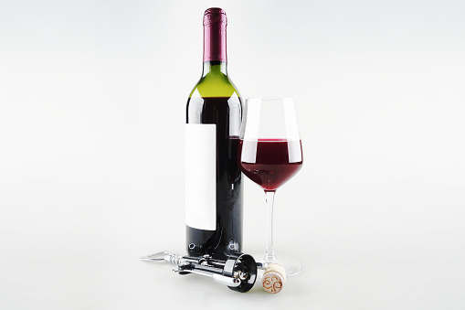 Bottle of wine with a glass on a white background