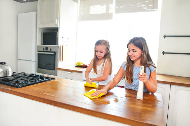 istock Two happy  little sisters cleaning kitchen table 1125100645