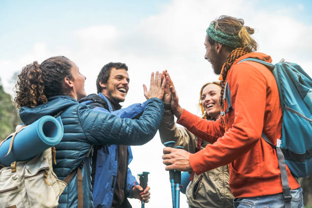 grupo de amigos, empilhando as mãos no pico da montanha - jovens turistas trekking e explorando a equipe da natureza selvagem - trekker, caminhar e viajar o conceito de pessoas - exploration group of people hiking climbing - fotografias e filmes do acervo