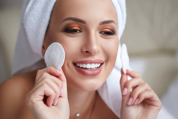 istock Young beautiful smiling woman with towel on her head holding cotton pads in her hands. Skin care, spa and beauty Treatments. Makeup removing. 1125113473