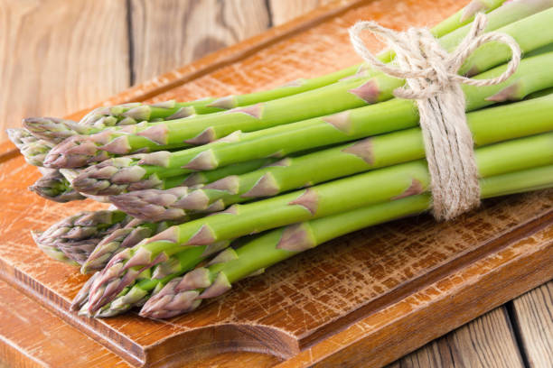 istock Green asparagus and wooden background 1125124542