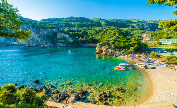 plage et bateau à paleokastritsa, corfou - beautiful bay sea water photos et images de collection